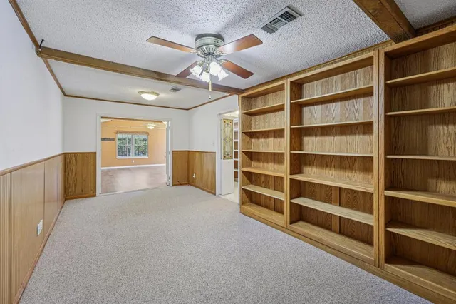 a view of an empty room with a cabinet and a window
