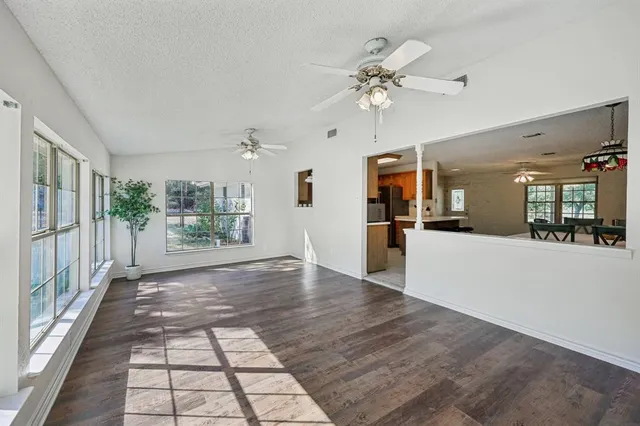 a view of a hallway view with wooden floor and a kitchen
