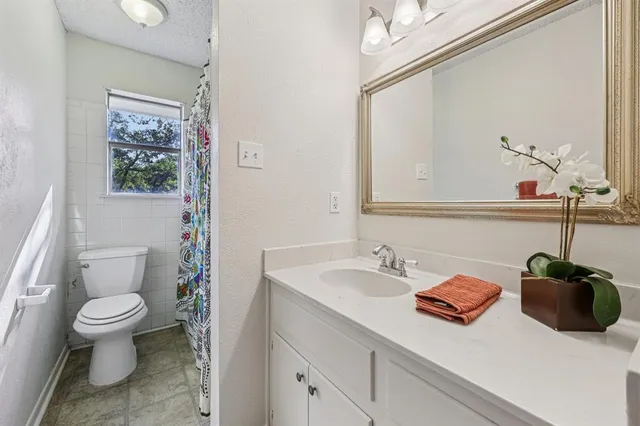 a bathroom with a sink a toilet and a mirror