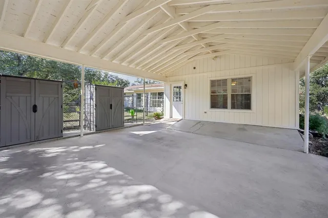 a view of house with a big yard and large trees