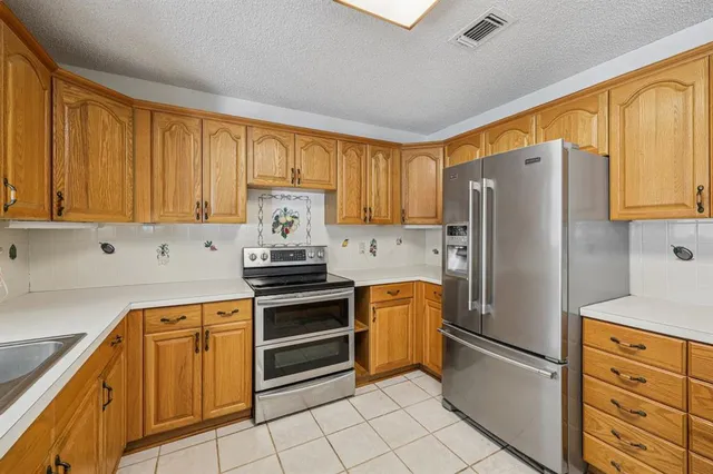 a kitchen with cabinets stainless steel appliances and a window