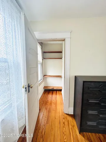 a view of closet with wooden floor