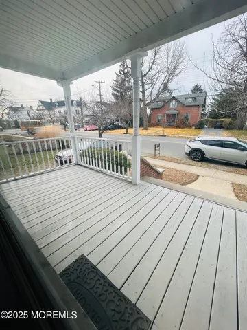 a view of balcony with wooden floor and seating space
