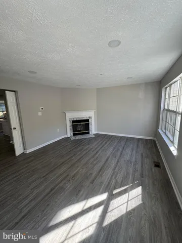 a view of empty room with wooden floor and window
