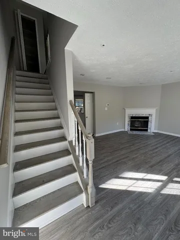 a view of a hallway with wooden floor and stairs