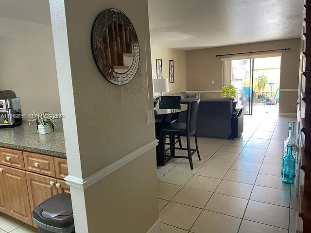 a dining room with furniture and a floor to ceiling window
