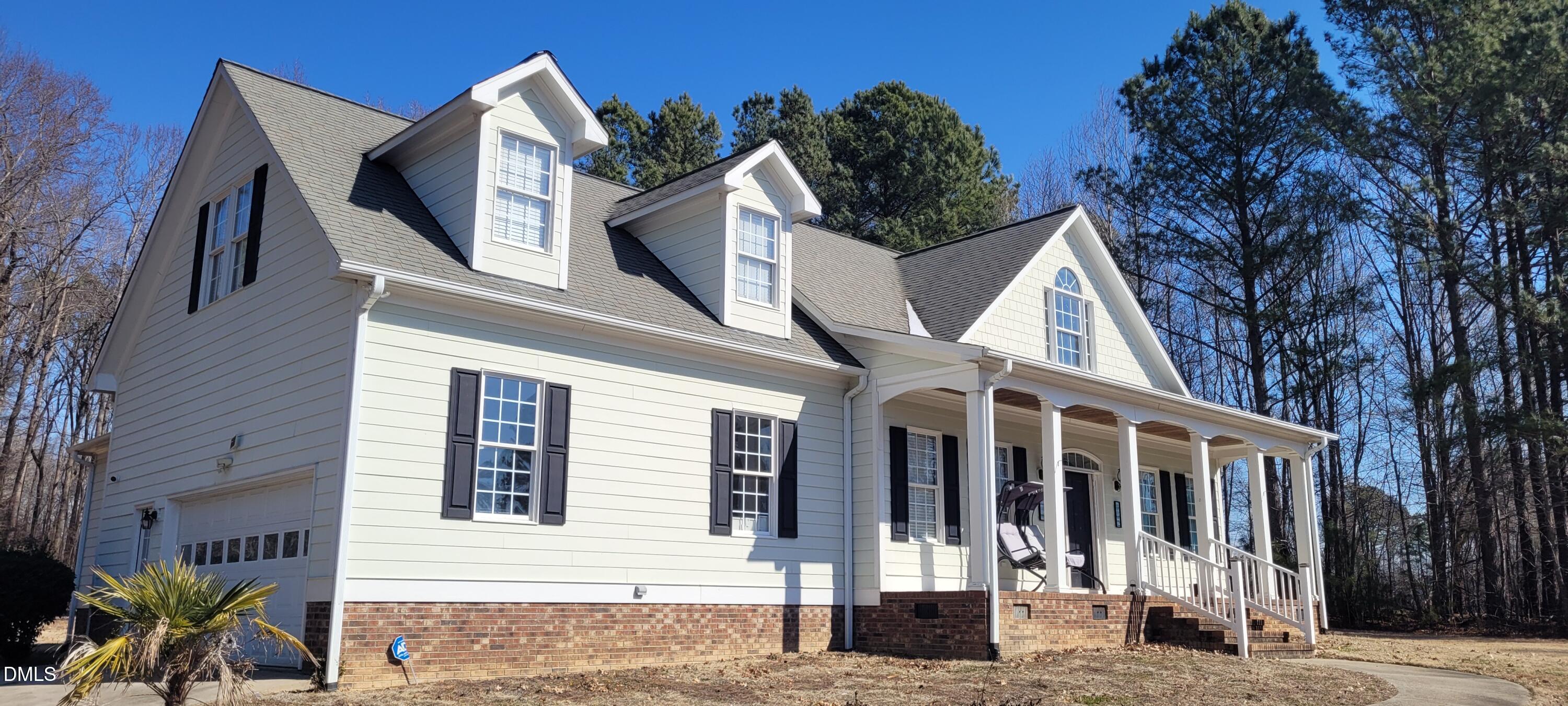 226 Fletcher Ridge Road Timberlake, NC 27583 - Photo 18 of 30 a view of a white house with large windows and a tree