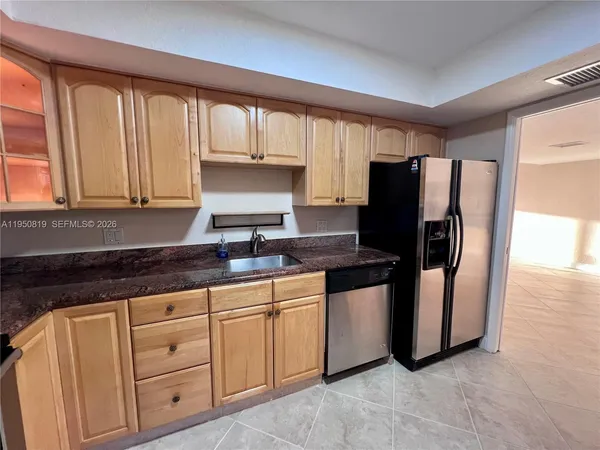 a kitchen with stainless steel appliances granite countertop a refrigerator sink and cabinets