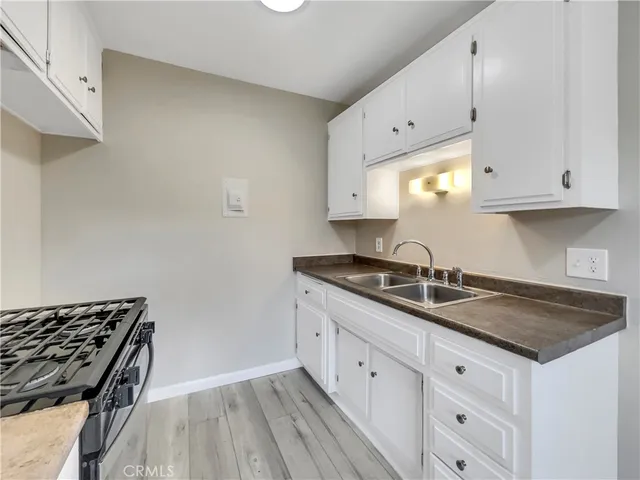 a kitchen with granite countertop white cabinets and a stove