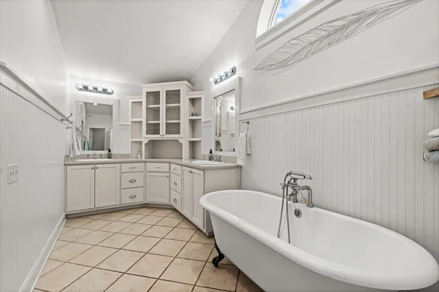 a bathroom with a bathtub sink and mirror