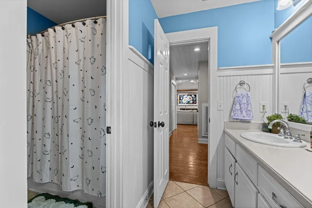 a bathroom with a sink and mirror with shower