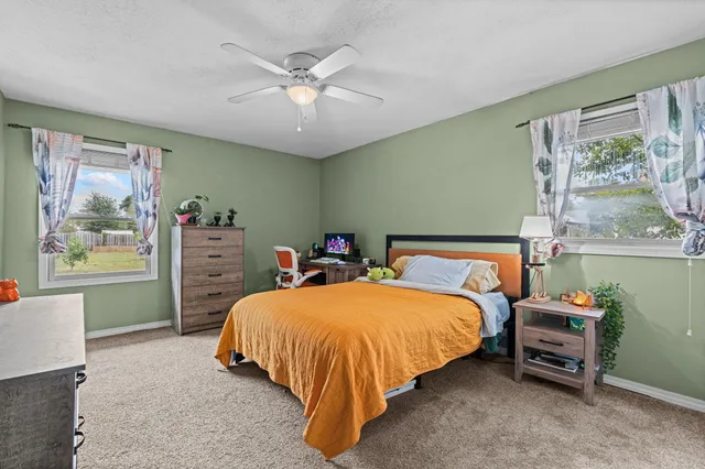 a spacious bedroom with a bed and a large window