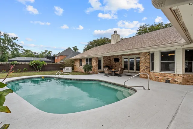 a view of a house with swimming pool and sitting area
