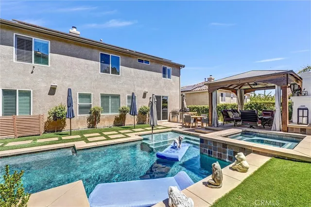 a view of a house with swimming pool and sitting area
