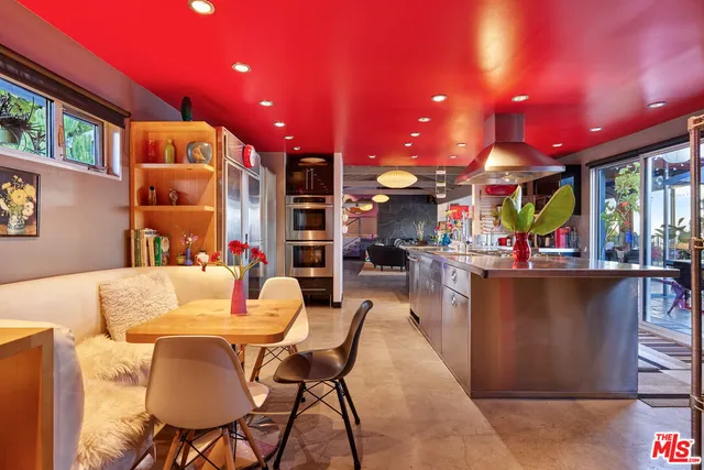 a living room with stainless steel appliances kitchen island granite countertop furniture and a large window