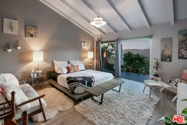 a bedroom with a bed a lamp and windows