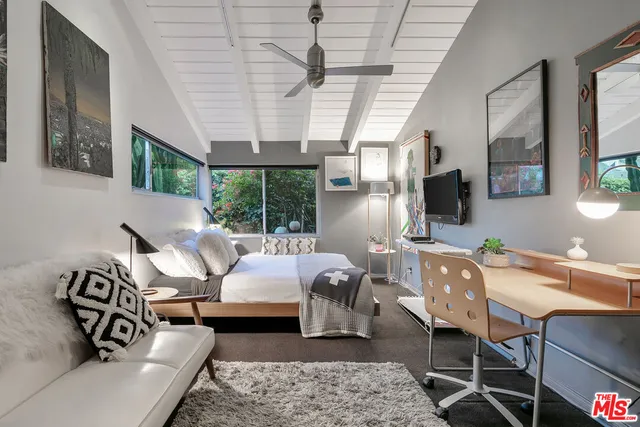 a living room with furniture a flat screen tv and a floor to ceiling window