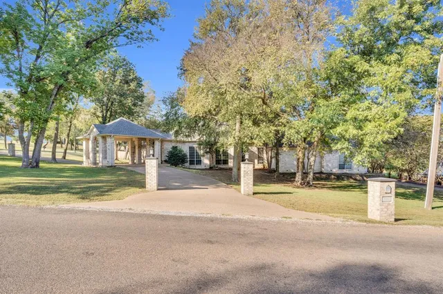 a view of large trees in front of a house
