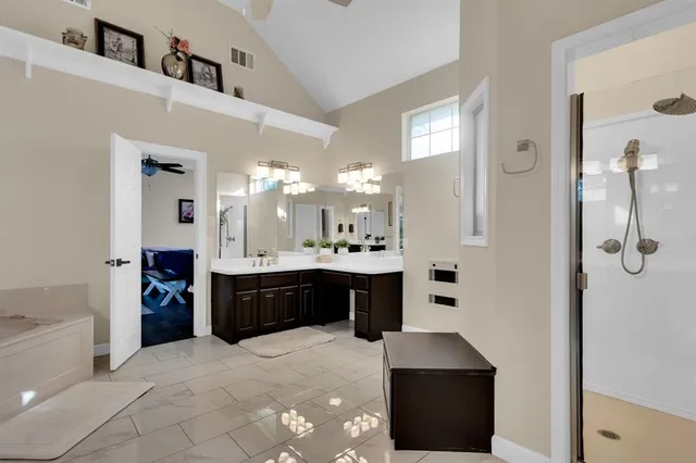 a large bathroom with a double vanity sink a large mirror and shower