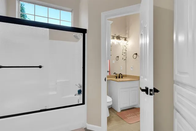 a bathroom with a sink and mirror with toilet
