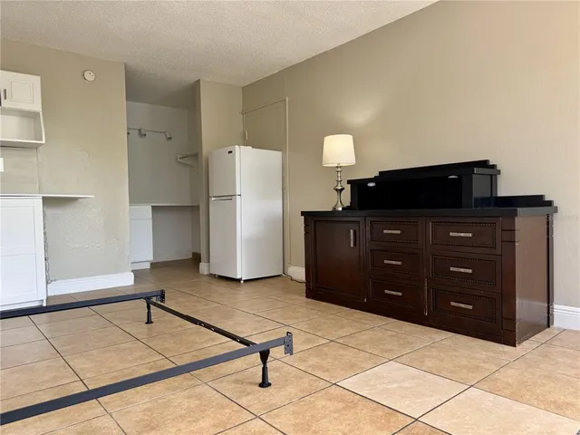 a room with a cabinets and a refrigerator