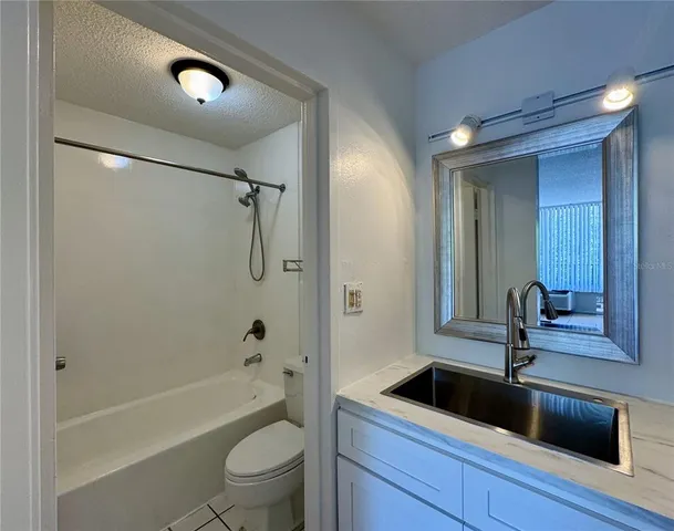 a bathroom with a tub a sink and mirror
