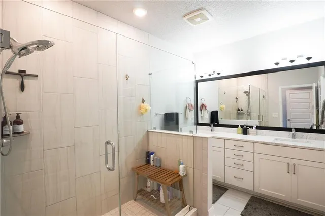 a bathroom with a sink vanity and shower
