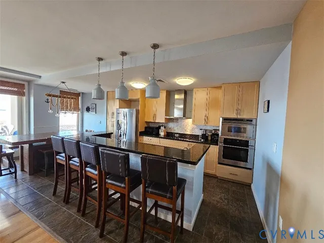 a kitchen with stainless steel appliances a table chairs and a refrigerator