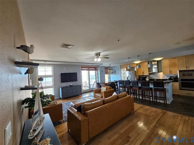 a living room with furniture kitchen view and a large window