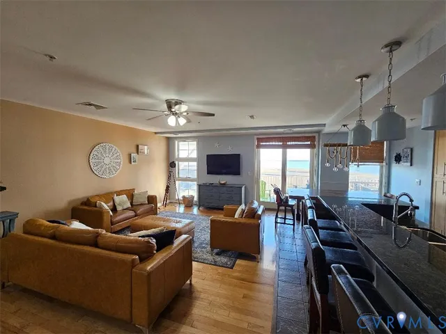 a living room with furniture kitchen view and a large window