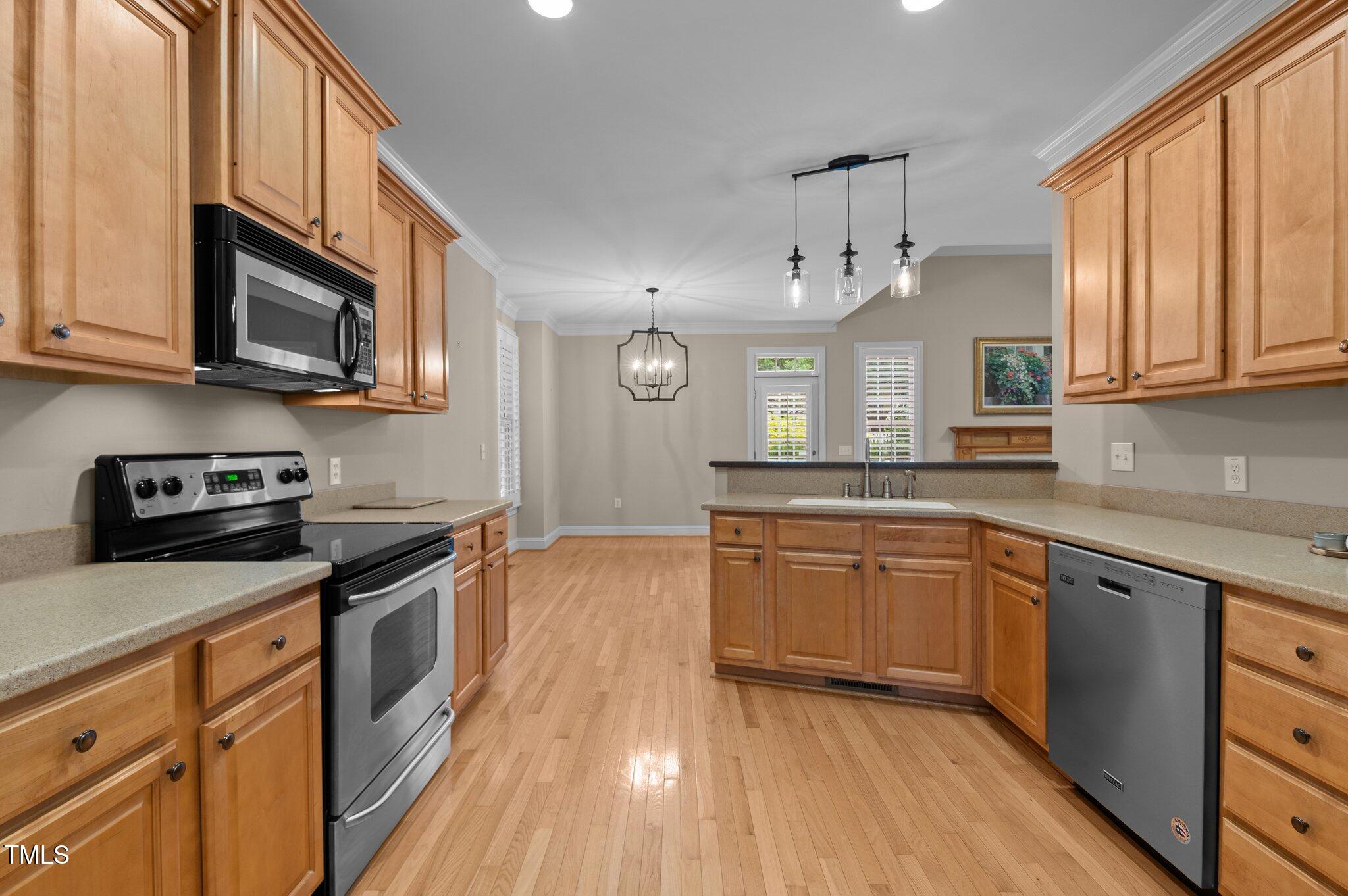 1012 Coram Fields Road Wake Forest, NC 27587 - Photo 10 of 38 a kitchen with stainless steel appliances granite countertop a stove a sink dishwasher and a microwave oven with wooden floor