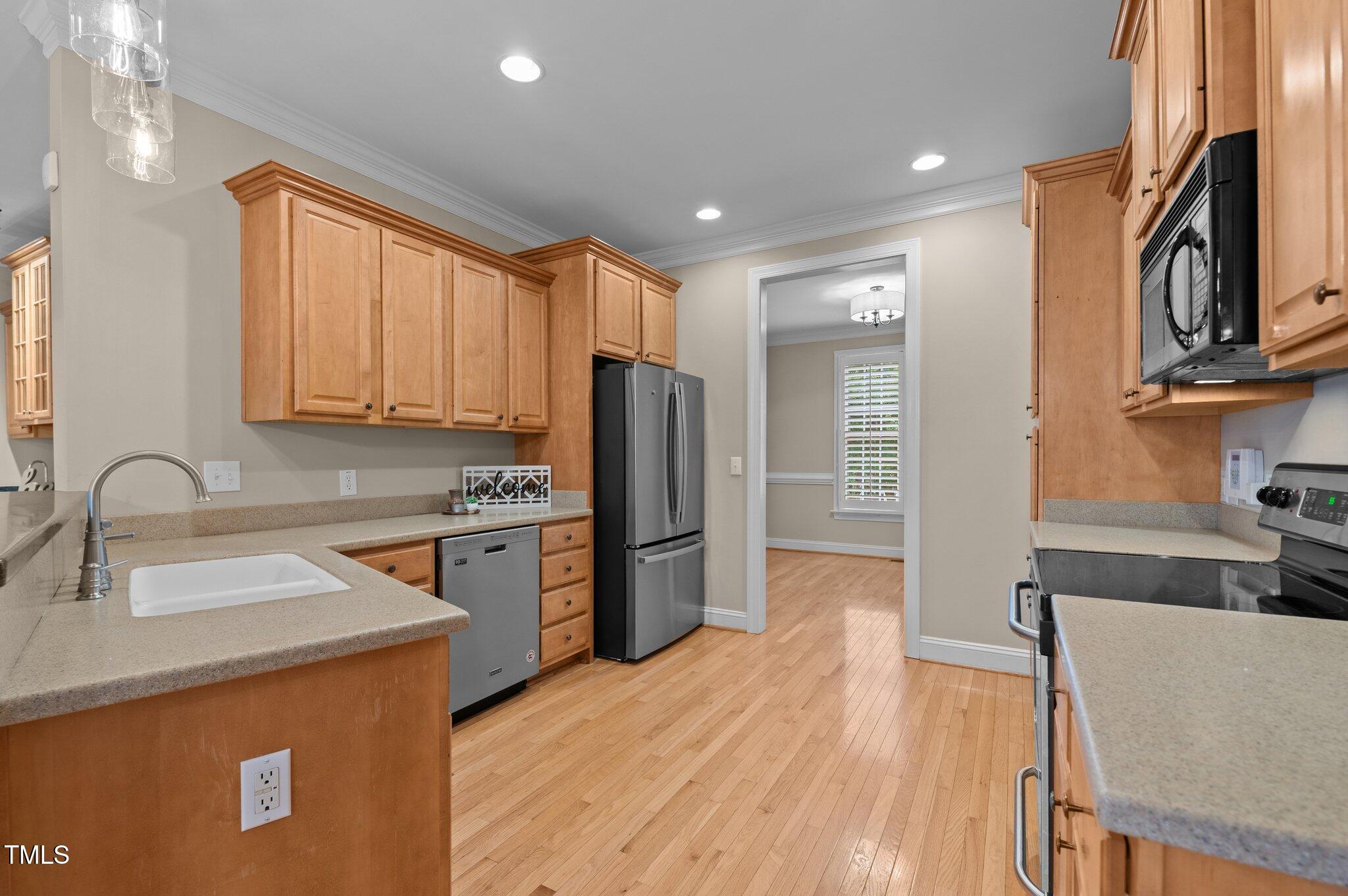 1012 Coram Fields Road Wake Forest, NC 27587 - Photo 13 of 38 a kitchen with a refrigerator sink and wooden cabinets