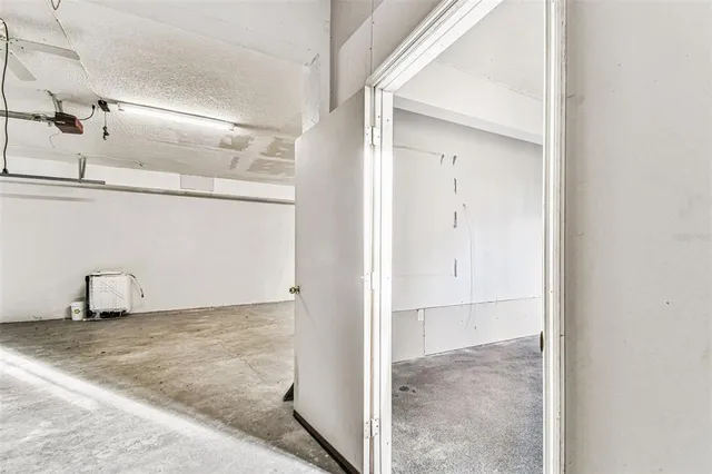 a view of a room with a ceiling fan and window