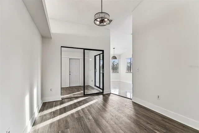 an empty room with wooden floor and closet area