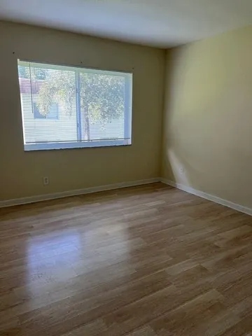 a view of a room with wooden floor and window