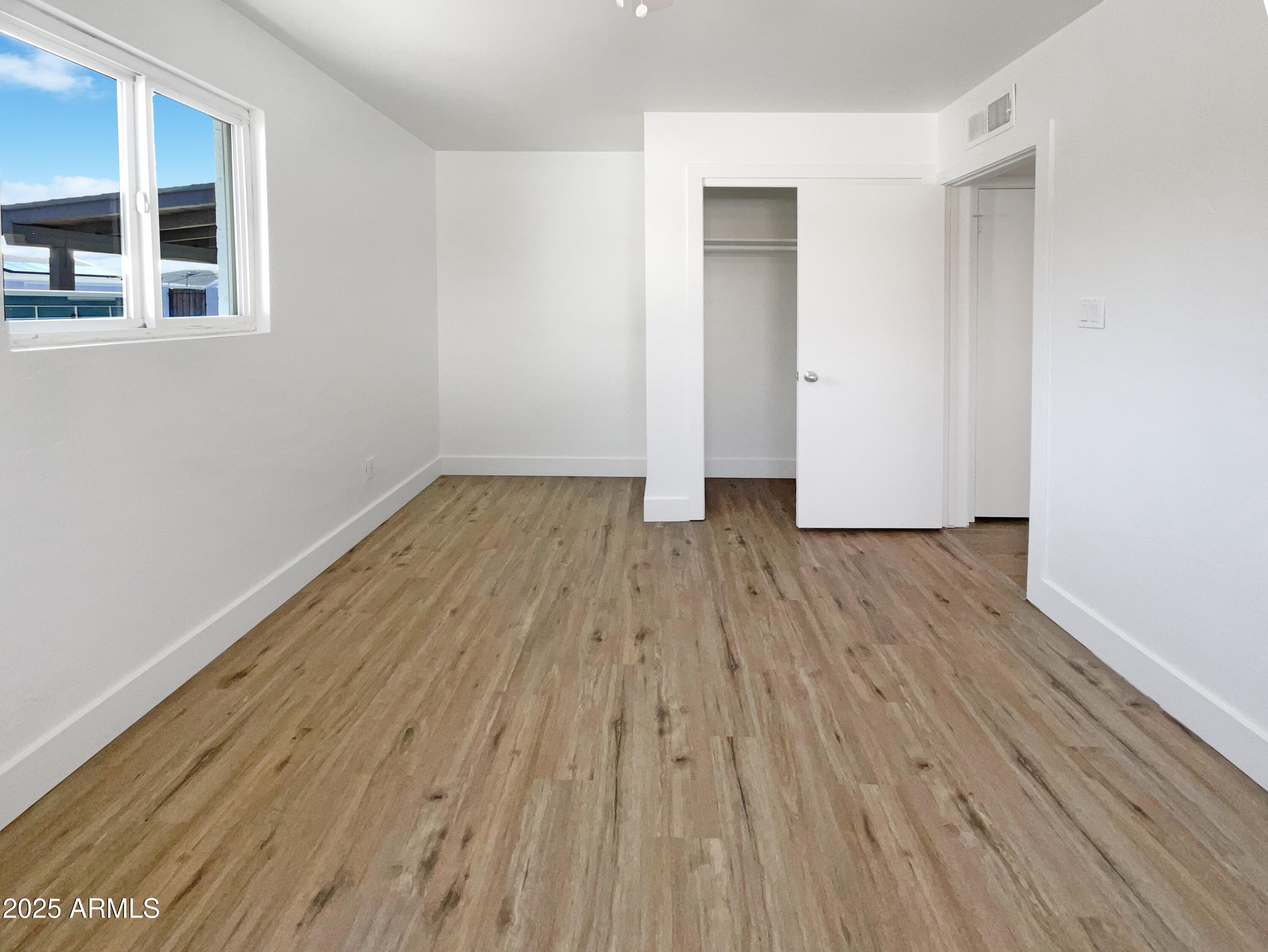 7231 North 23rd Avenue Phoenix, AZ 85021 - Photo 14 of 28 an empty room with wooden floor and windows