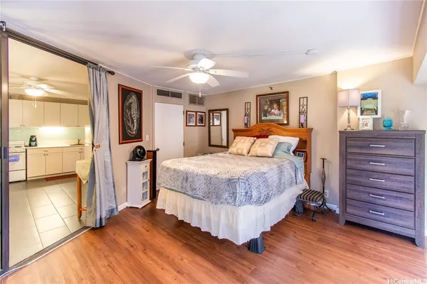 a bedroom with a large bed and a flat tv screen on dresser
