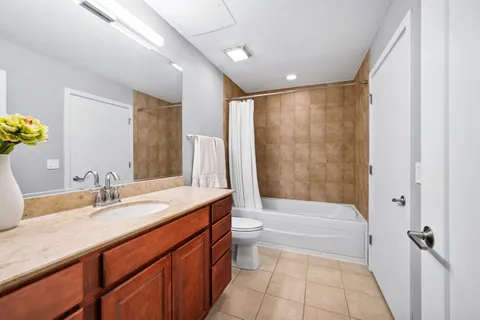 a bathroom with a granite countertop sink a toilet and shower
