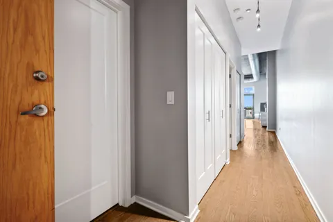 a view of a hallway with wooden floor and staircase