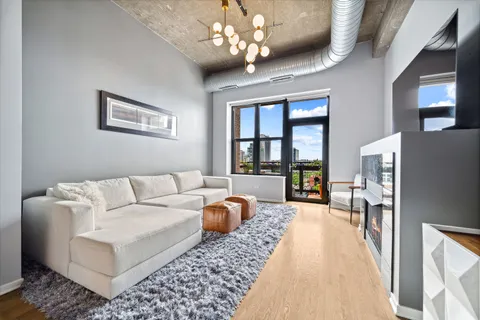 a living room with furniture a chandelier and a dining table