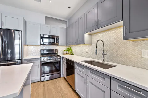 a kitchen with kitchen island granite countertop a sink stainless steel appliances and cabinets
