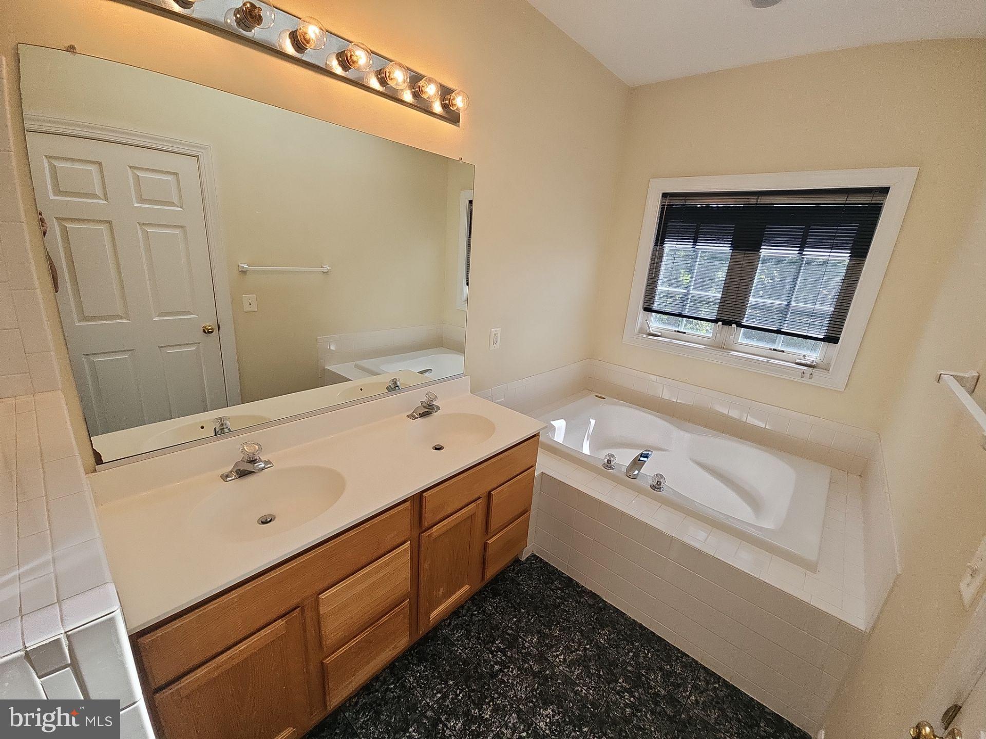 6681 Debra Lu Way Springfield, VA 22150 - Photo 45 of 57 a bathroom with a tub sink and mirror
