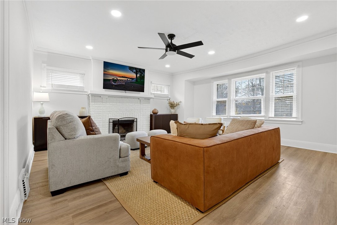 3326 East Overlook Road Cleveland Heights, OH 44118 - Photo 5 of 29 Living room featuring light wood-finish flooring, a painted brick fireplace with a black metal screen, and recessed lighting