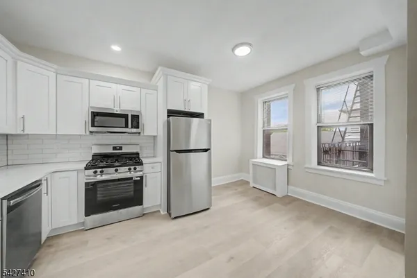 a kitchen with refrigerator a stove a microwave and cabinets