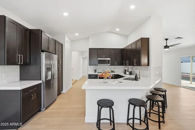 a kitchen with stainless steel appliances a sink stove refrigerator and cabinets