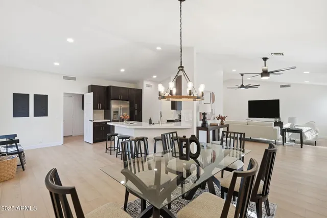 a view of a dining room and livingroom with furniture wooden floor a chandelier
