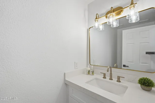 a bathroom with a sink vanity and a mirror