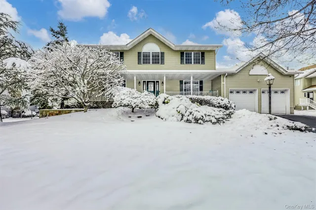 a front view of a house with a yard covered with snow