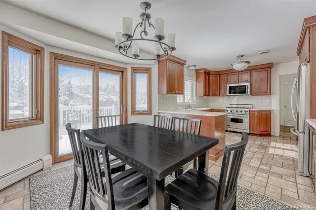a view of a dining room with furniture a chandelier and wooden floor