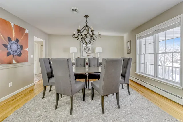 a view of a dining room with furniture a chandelier and wooden floor